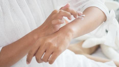 Žena nanášení Bepanthen DERMA mléko na kůži