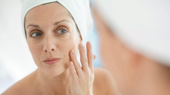 Žena se dotýká tváře po použití produktu Bepanthen DERMA